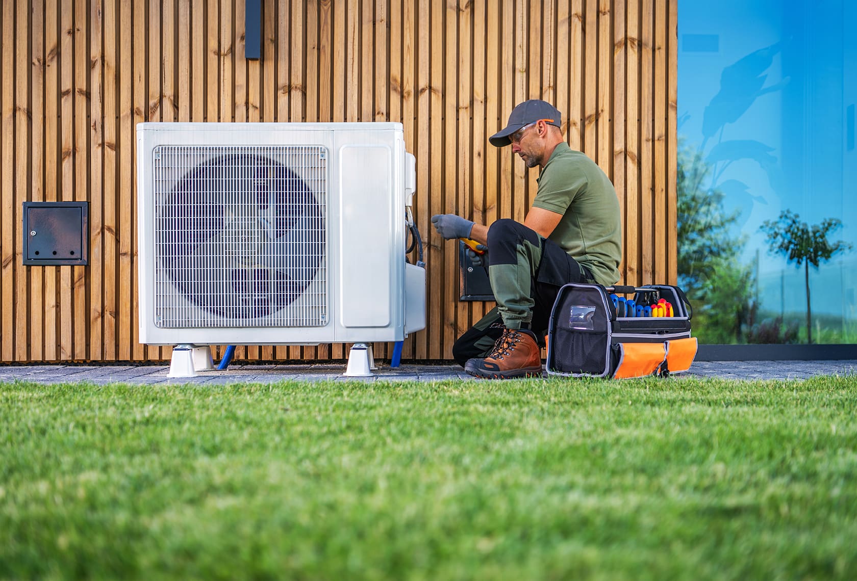 暖通空調技師正在為住宅外的一台電熱泵機組進行維修